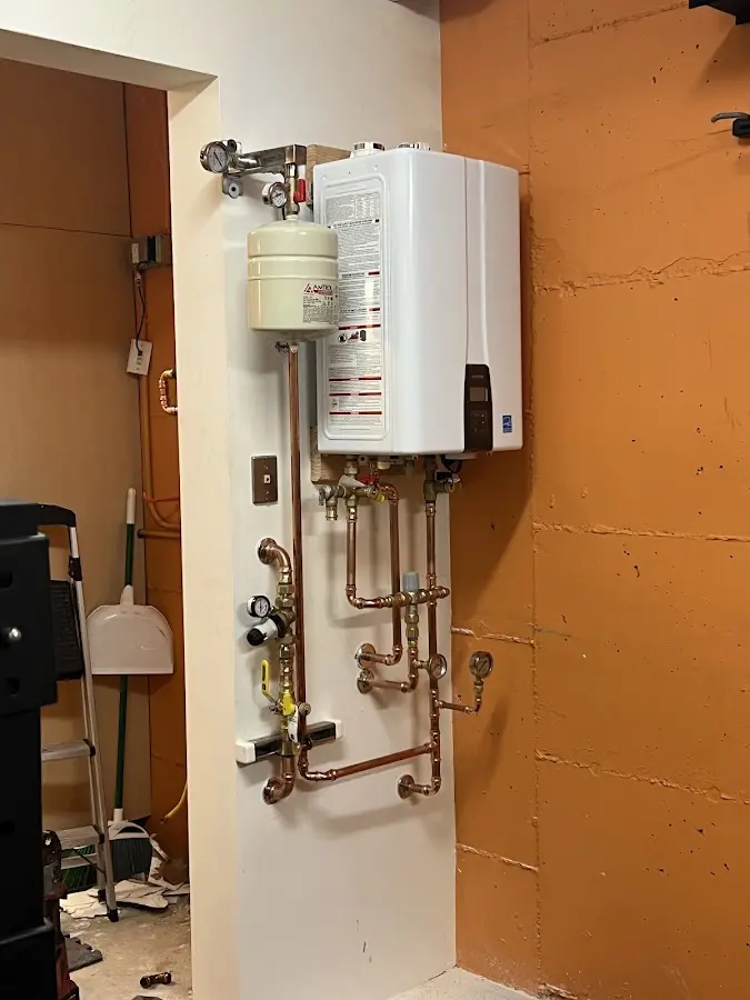 Plumbing technician inspecting water heater connections in East Stroudsburg